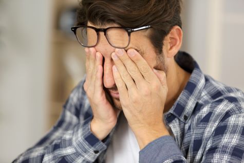 Man with his hands pressed against his eyes and sinuses